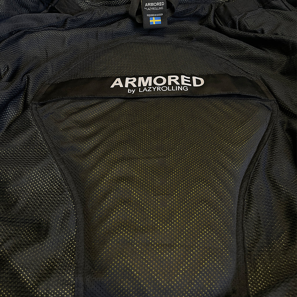 The inside of the black on black armored reflective performance hoodie showing the placement of the back protection pad